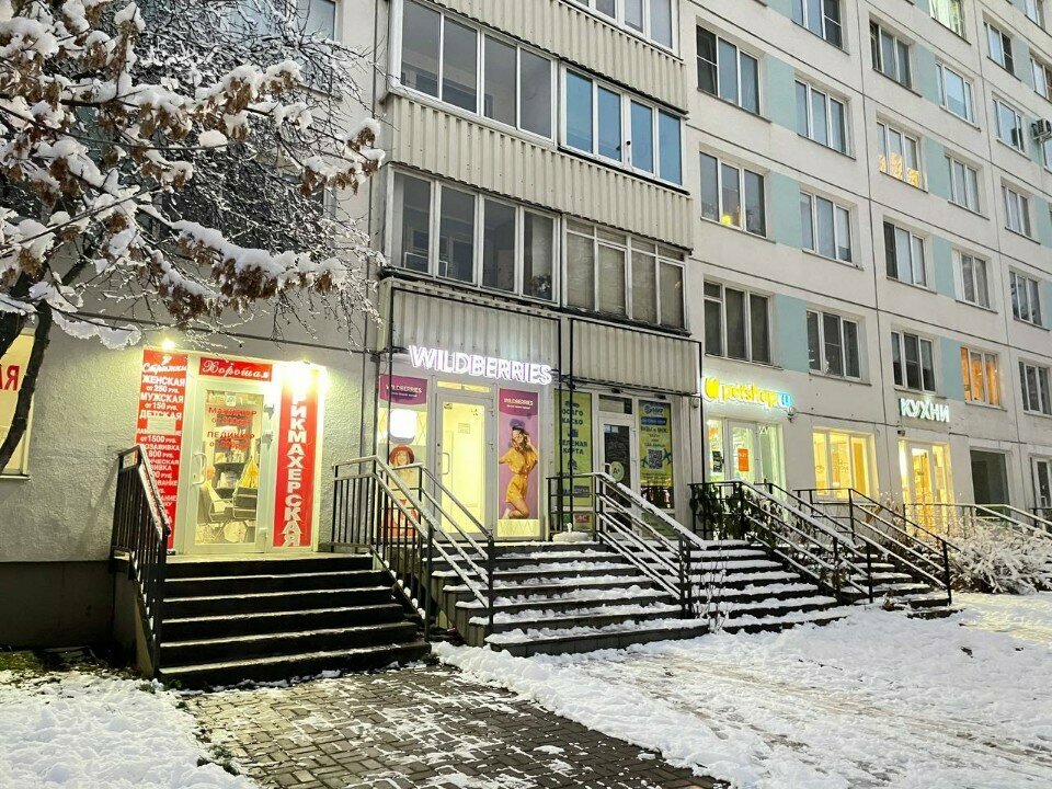 Зимний фасад здания и вход в парикмахерскую на проспекте Науки